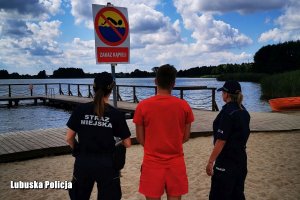 policjantka, strażniczka miejska i ratownik stoją na plaży