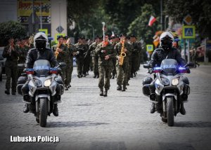 Policyjne motocykle prowadzą defiladę pododdziałów wojskowych.
