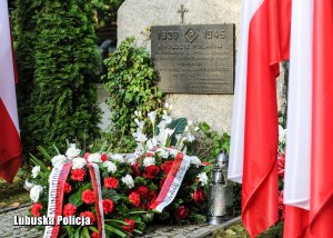 Pomnik poświęcony ofiarom drugiej wojny światowej i flagi biało czerwone.