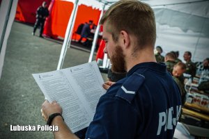 Policjant podczas czytania formularza dotyczącego zbiórki krwi.