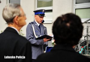 Kobieta z mężczyzną. W tle policjant czyta tekst