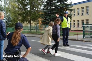 dzieci uczą się bezpiecznego zachowania przy przejściu dla pieszych