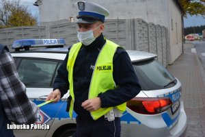 policjant przekazuje odblask pieszemu