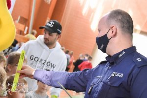 policjant oraz Bartosz Zmarzlik rozdają odblaski