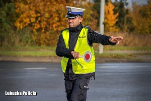 Policjant ruchu drogowego daje znak do zatrzymania i zjazdu