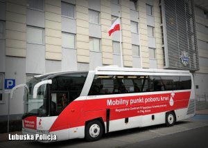 Krwiobus zaparkowany przed budynkiem komendy Policji.