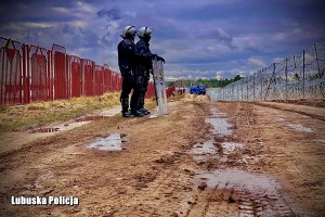 dwóch policjantów w umundurowaniu szturmowym na granicy