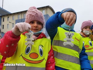 dzieci trzymające odblaski, które otrzymały od policjantów