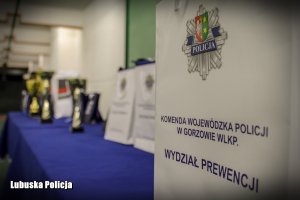 Baner Komendy Wojewódzkiej Policji w Gorzowie Wielkopolskim przy stole z nagrodami