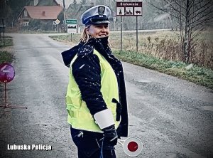 Policjantka ruchu drogowego na jezdni podczas służby  na drodze.