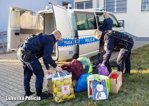 policjanci pakują torby do radiowozu