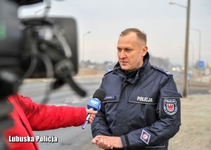 Policjant udziela wywiadu telewizyjnego.