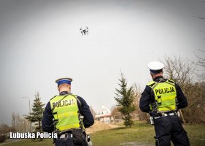 Policjanci drogówki a nad nim wznoszący się w powietrze dron.