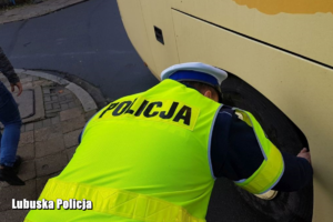 policjant kontroluje stan ogumienia w autokarze