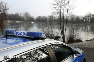 Policyjny radiowóz na tle jeziora