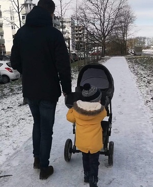 Mężczyzna z dzieckiem i z wózkiem na spacerze