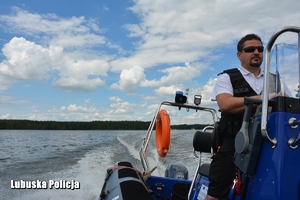 policjant sterujący łodzią motorową