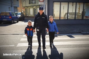 Policjantka przeprowadza dzieci przez przejście dla pieszych