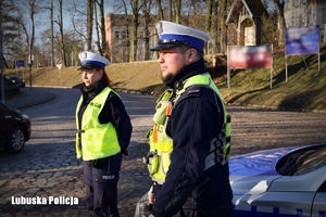 Policjant i policjantka obserwują ruch drogowy