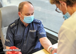 Policjant podczas rejestracji przy oddawaniu krwi.