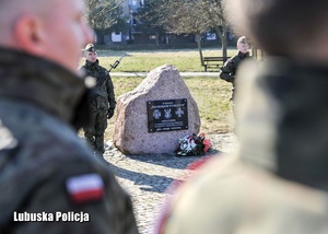 Żołnierze stojący przed pomnikiem ku czci Żołnierzy Wyklętych.