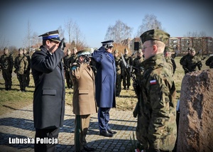 Przedstawiciele służb mundurowych oddają hołd przed pomnikiem Żołnierzy Wyklętych.