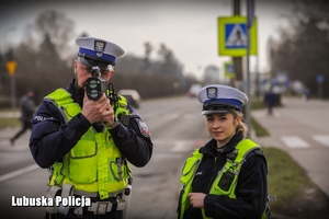 Policjant i policjantka mierzą prędkość pojazdu