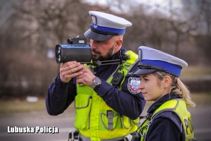 Policjant i policjantka podczas mierzenia prędkości