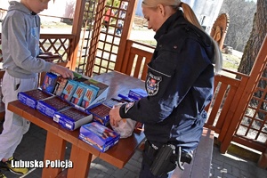 Policjantka i chłopiec z zebranymi produktami dla uchodźców