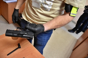 pistolet gazowy trzymany przez policjanta