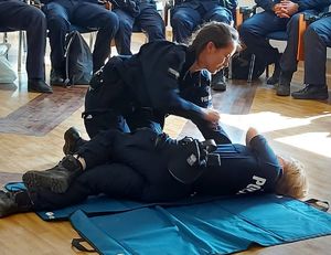 Policjantka przy ćwiczeniach z pierwszej pomocy