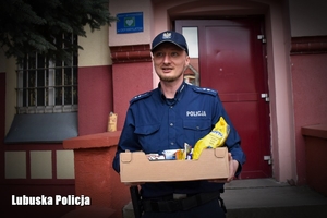 Policjant trzyma kosz z produktami