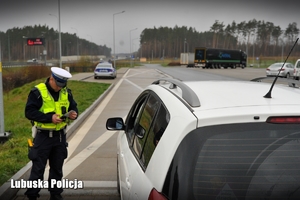 Policjant drogówki podczas legitymowania kierowcy.