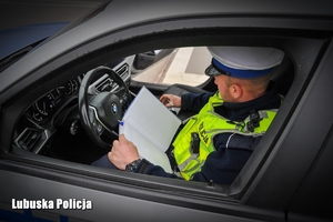 Policjant drogówki podczas sporządzania wpisu w notatniku służbowym.