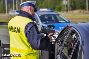 policjant pokazuje kierowcy wynik na laserowym mierniku