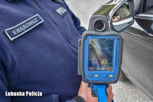 policjant trzyma laserowy miernik prędkości