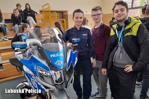 Policjantka przy policyjnym motocyklu razem z młodzieżą