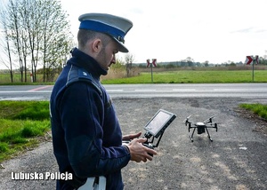 Policjant obsługujący konsolę sterującą dronem