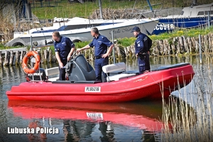 Policjanci wypływają łodzią na akwen