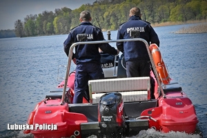 Policjanci na łodzi motorowej pływają po jeziorze