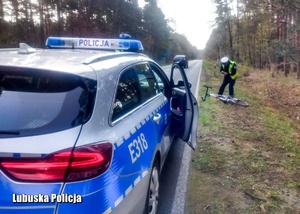Policjant wykonuje oględziny w miejscu wypadku drogowego