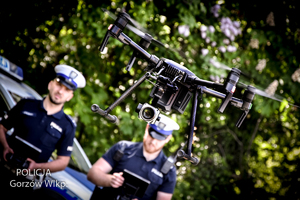 Policyjny dron a w tle policjanci