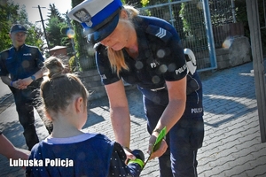 Policjantka rozdaje odblaski dzieciom