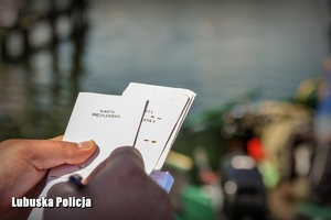 policjant trzyma karty wędkarskie