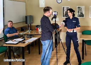 Dziennikarz przeprowadza wywiad z policjantką podczas warsztatów.