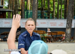 Policjantka z dziećmi na spotkaniu profilaktycznym.
