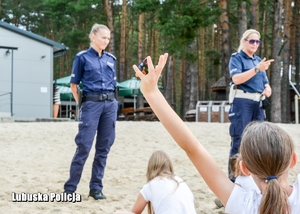 Policjanci na plaży rozmawiają z dziećmi