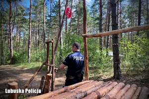 Policjant sprawdza bramę obozu