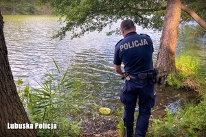 Policjant sprawdza brzeg jeziora