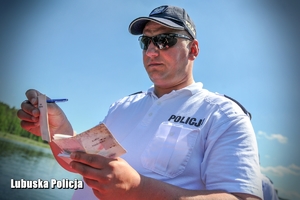 policjant sprawdza dokumenty